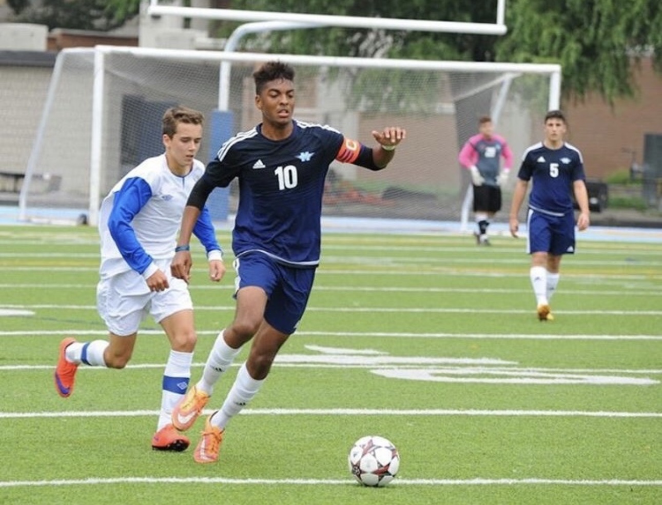 The Pathwai founder wearing the captain’s armband and number 10, driving forward with the ball